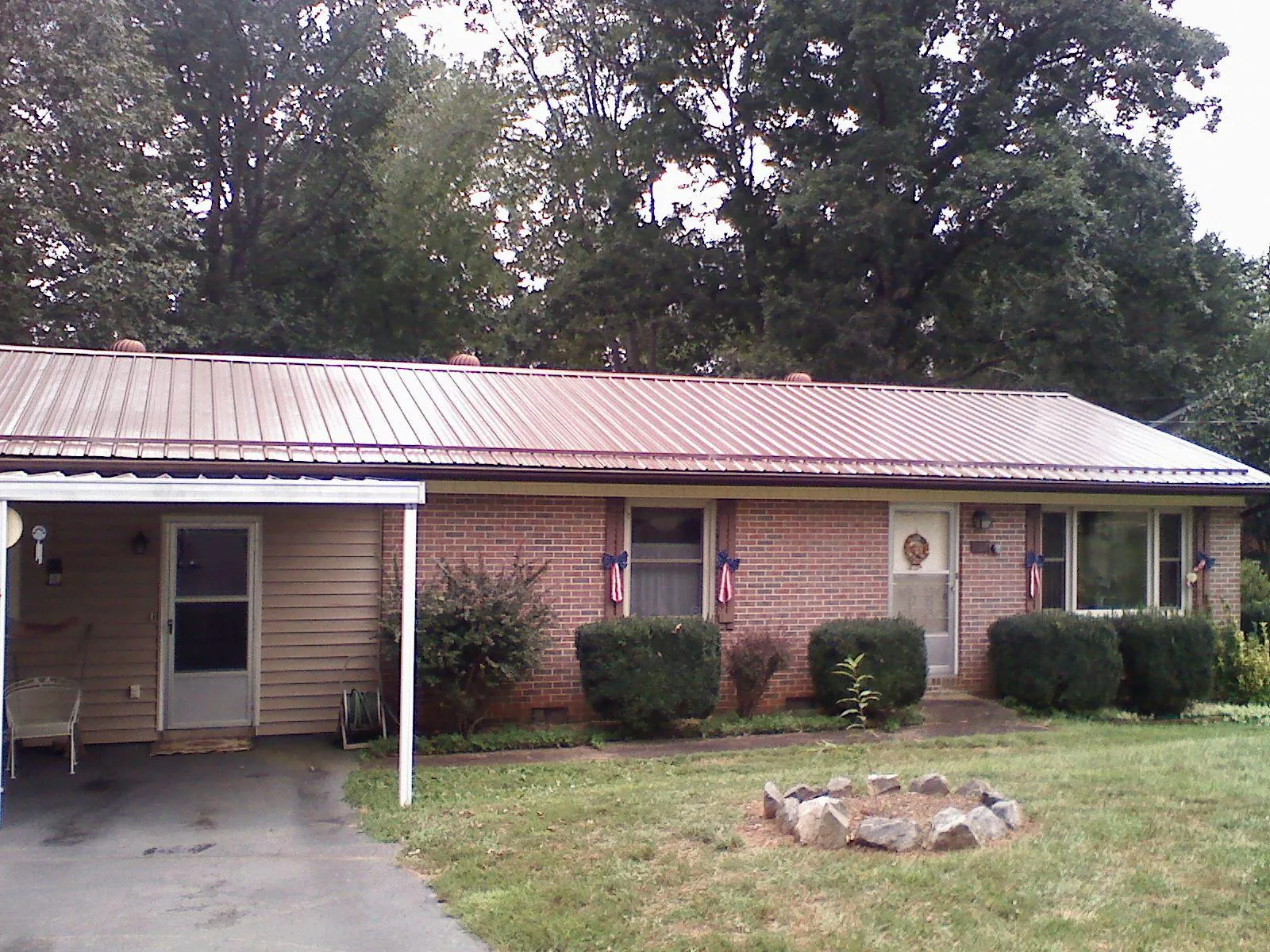 Bronze metal roof and carport on a brick ranch home — Roof Repair work by our crew in Bainbridge